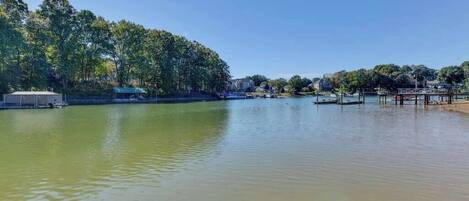 A calm lake with a dock and a covered area on the left.