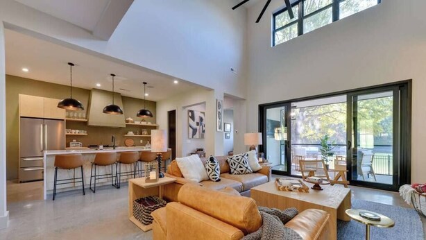 A modern open-plan living area with a kitchen, a sofa set, and a dining table. - Spacious Lakefront Retreat, Enjoy Dock and Pool (Mooresville)