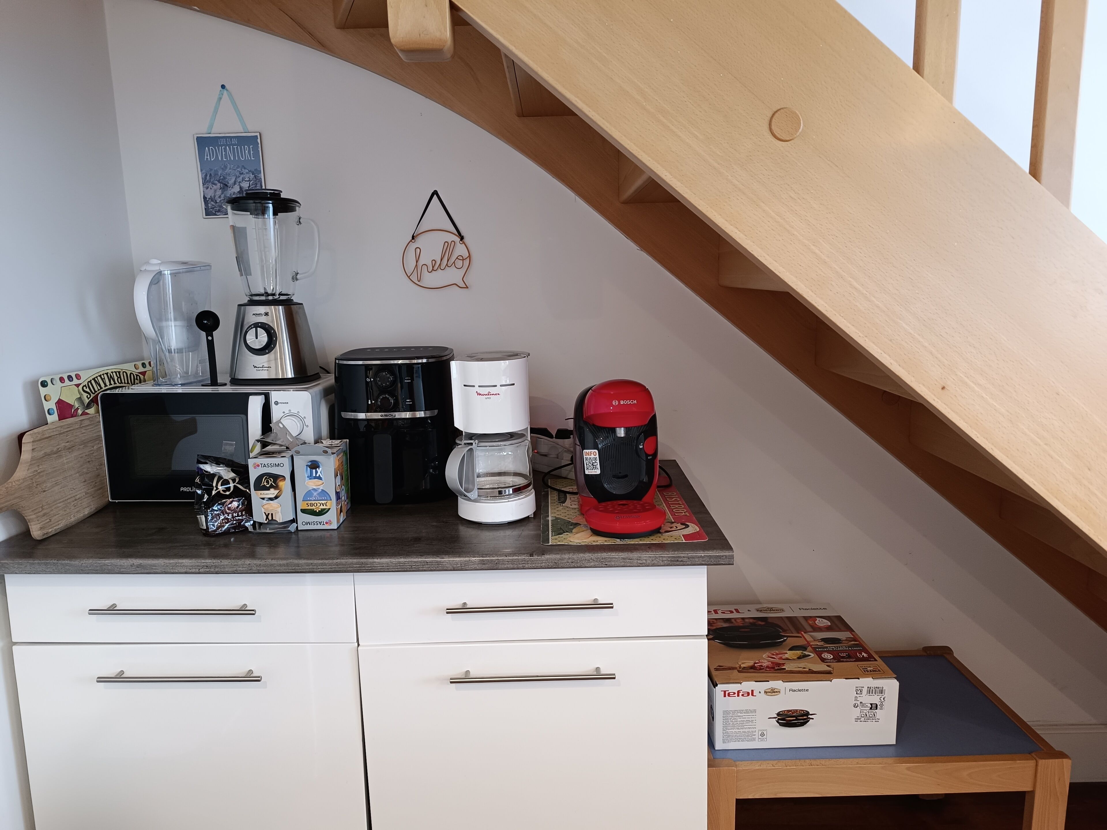 Una cocina con cafetera, tostadora, licuadora y una caja de máquina para pasta Tefal.