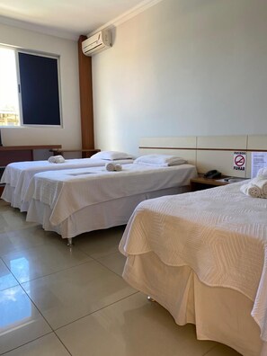 A hotel room with two beds, a window, an air conditioning unit, and a sign prohibiting smoking. - Zeta Hotel (Nova Uniao)