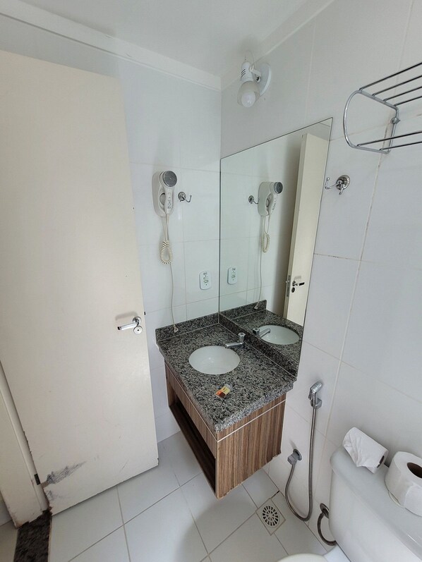 A bathroom with two sinks, a mirror, a towel rack, and a shower.