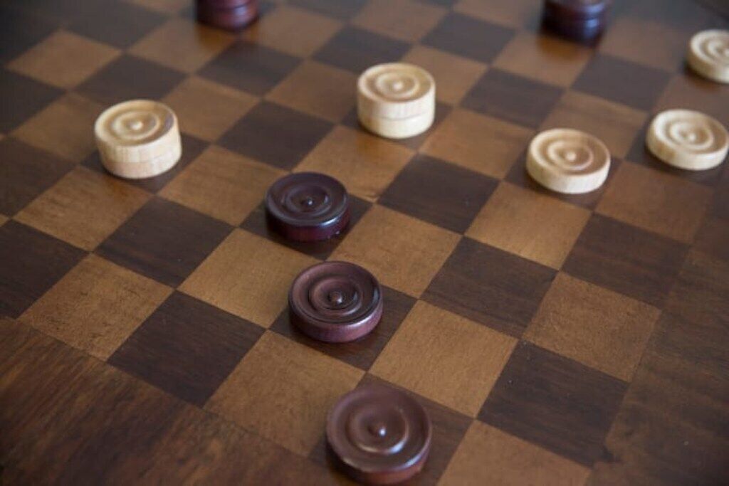A checkered board with pieces in various positions.
