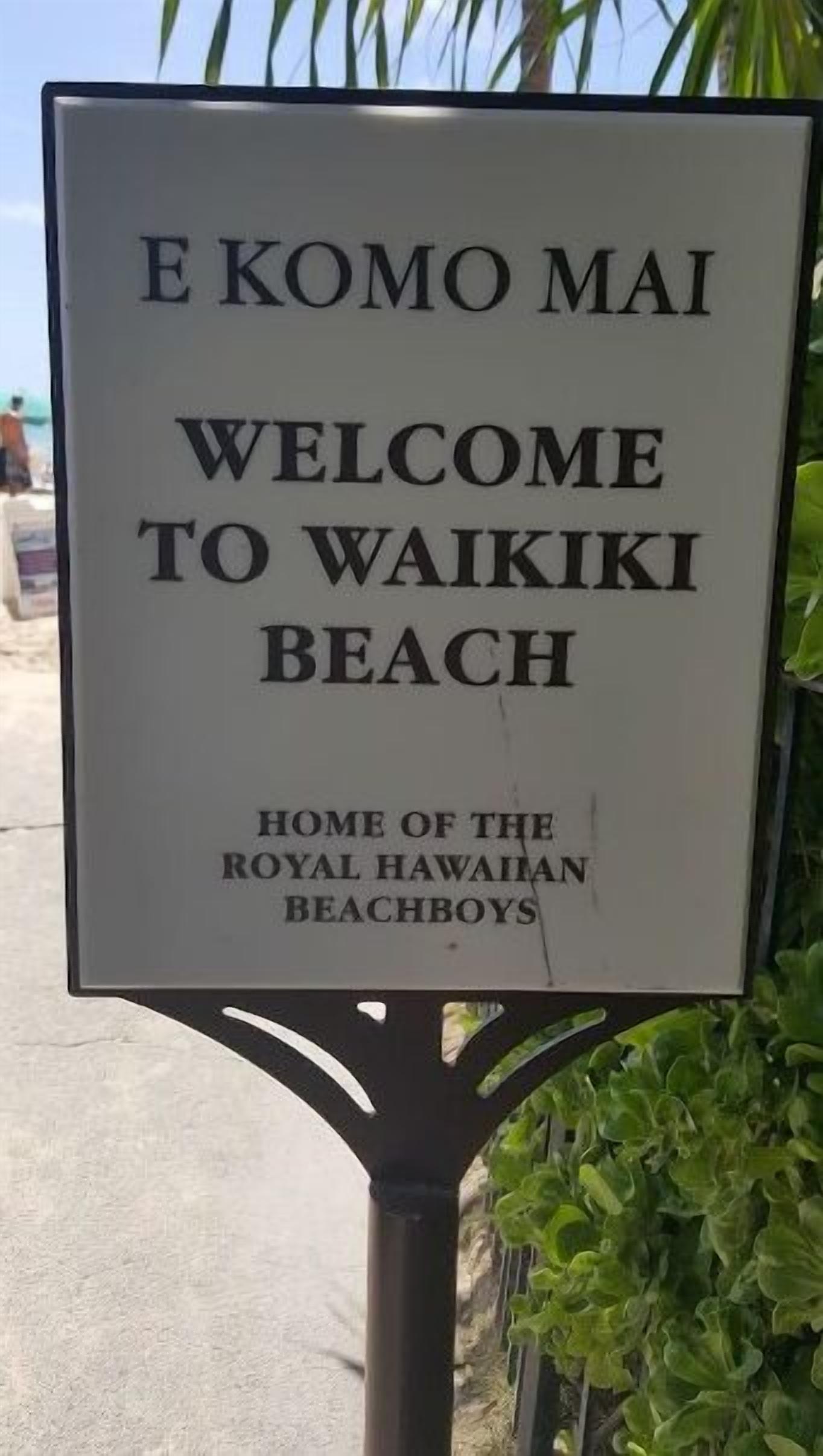 Un letrero da la bienvenida a visitantes a la playa de Waikiki, indicando que es el hogar de los Royal Hawaiian Beachboys.
