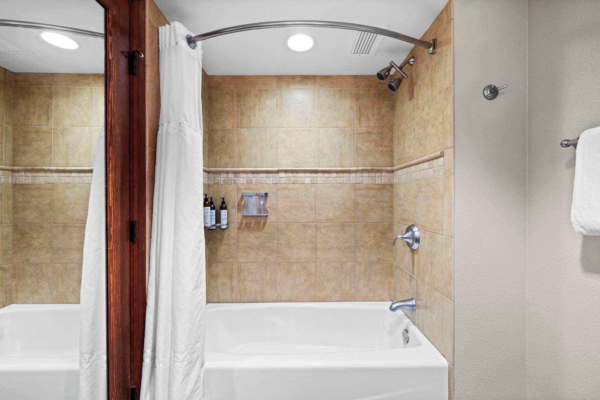 Une salle de bain avec une baignoire, une douche et un porte-serviettes.