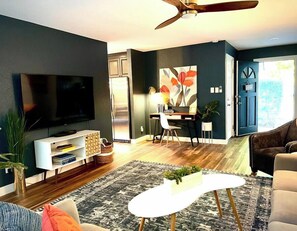 A modern living room with a flat-screen TV, a dining area with a table and chairs, and a ceiling fan. - Remodeled 4BR near Maidu Park · Roseville/Granite Bay · Pets OK (Roseville)