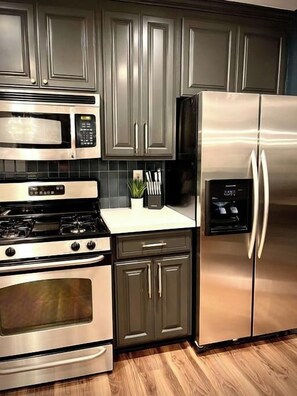 A kitchen with stainless steel appliances, including a microwave, stove, oven, and refrigerator. - Remodeled 4BR near Maidu Park · Roseville/Granite Bay · Pets OK (Roseville)