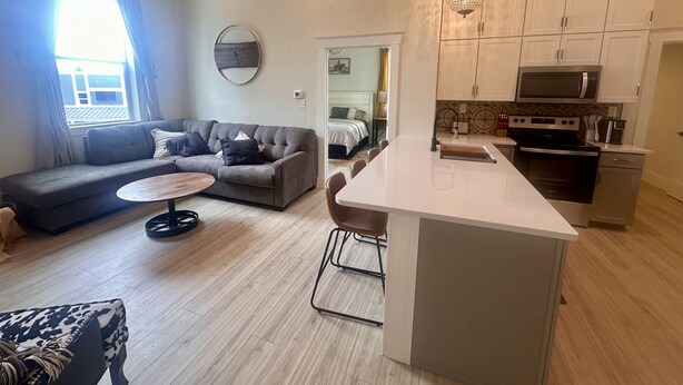 A modern apartment with a living area, a dining space, and a kitchenette. - Opera House Suite 1 (Kemmerer)
