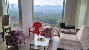 A spacious living room with a large window offering a city view, a sofa, two armchairs, and a coffee table. - Habitación floridablanca 1 o 2 personas  (Floridablanca)