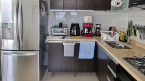 A modern kitchen with stainless steel appliances, a built-in oven, a coffee maker, and a knife rack. - Habitación floridablanca 1 o 2 personas  (Floridablanca)