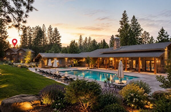 A residential property with a swimming pool, outdoor seating, and a large house with multiple rooms.