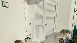 A set of steps leading to a white door with shutters, decorated with colorful tiles and potted plants. - Room with chromotherapy shower separate entrance (Alcamo)