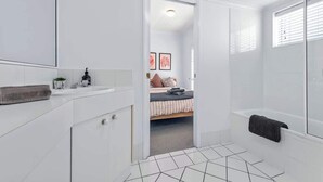 Une salle de bain moderne équipée d’une baignoire, d’une douche et de toilettes.
