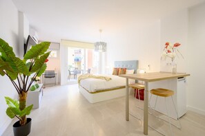 Ein modernes Schlafzimmer mit Bett, Nachttisch und einem Topf mit Pflanze.
