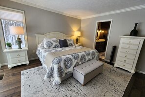 A bedroom with a bed, nightstands, a dresser, and a window with blinds. - Completely remodeled Up North condo near clubhouse at Birchwood Farms (Harbor Springs)