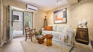 A living room with a sofa, a wooden chair, a coffee table, and a cabinet. - Holiday home with air conditioning and internet (Grožnjan)