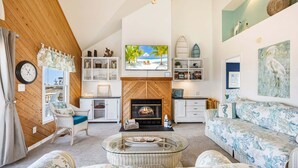 A cozy living room with a fireplace, a television, and a bookshelf.