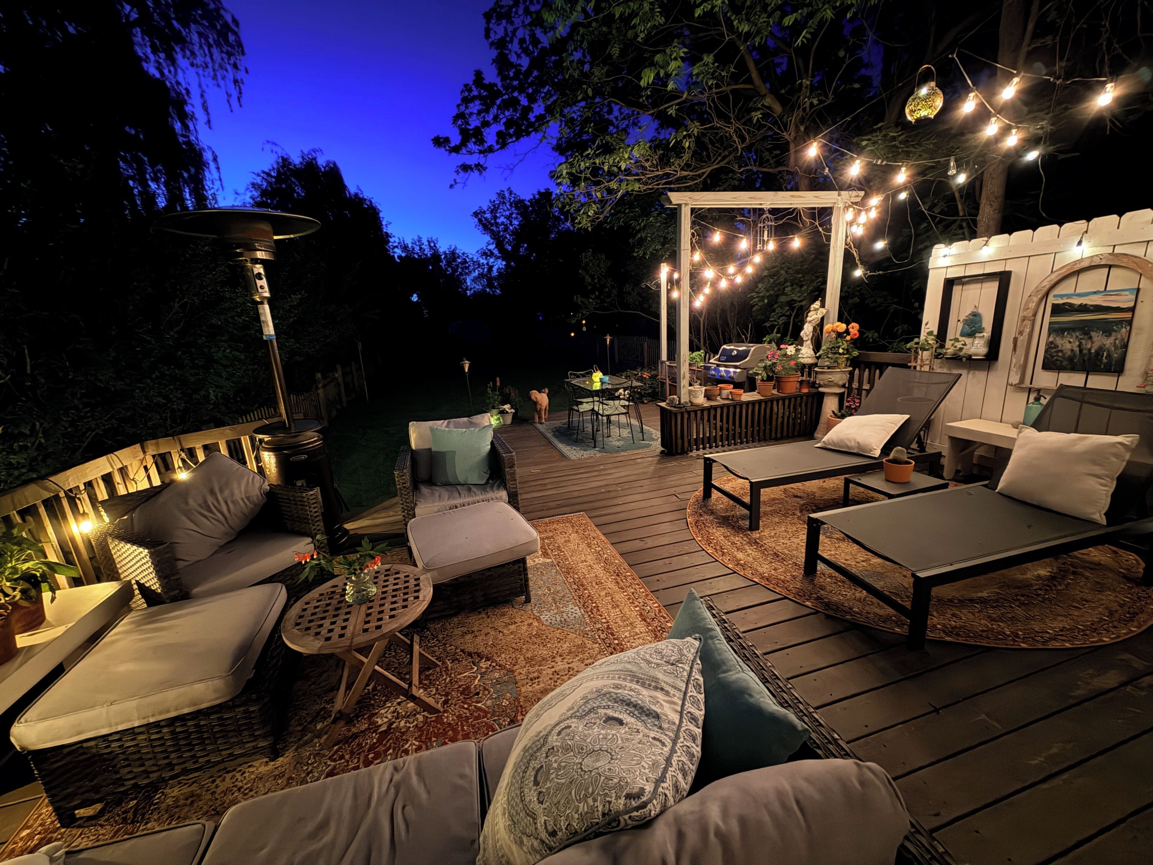 An outdoor deck with seating, a barbecue area, and string lights.