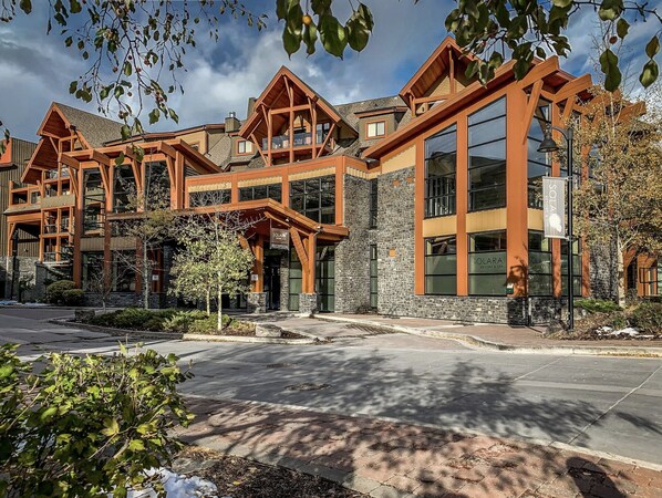 A lodge with a reception area, large windows, and a stone facade. - A unique mountain escape at Solara Resort & Spa in the heart of Canmore. (Canmore)