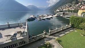 A marina with boats docked, a waterfront promenade, and a mountainous backdrop. - Casa Beverly 2 - My Home in Como (Argegno)