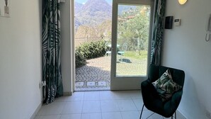 Une pièce dotée d’une porte-fenêtre coulissante donnant sur un balcon avec vue sur les montagnes.