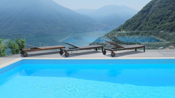 Une piscine avec vue sur les montagnes et un lac.