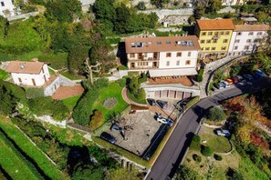 Vista aérea de una zona residencial con una casa de dos pisos, un estacionamiento y zonas verdes circundantes.