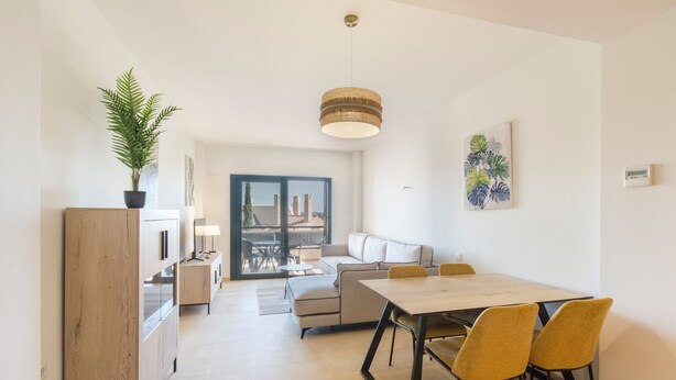 Eine moderne Küche mit Essbereich, einer Couch und einem großen Fenster.