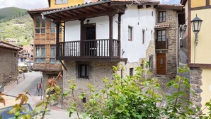 A traditional building with a balcony, stone walls, and a wooden door. - Holiday Home 'Casa Raymonde' with Mountain View, Balcony and Wi-Fi (Potes)
