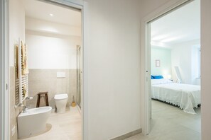 A modern bathroom with a bathtub, toilet, and shower. - 'In the Heart of Radicondoli' Apartment with Wi-Fi (Radicondoli)
