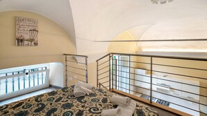 A bedroom with a bed, a window, a balcony, and a wall-mounted sign.