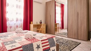 A bedroom with a bed, a desk, a wardrobe, and a mirror. - Holiday Apartment "Casa Laureta" with Private Terrace & Wi-Fi (Piombino)