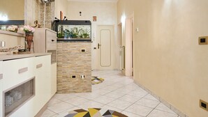 A modern kitchen with a built-in stove, a glass-top island, and a decorative vase with flowers. - Holiday Apartment "Casa Laureta" with Private Terrace & Wi-Fi (Piombino)
