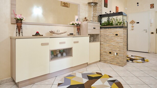 A modern kitchen with a large island, a built-in fish tank, and a decorative mirror. - Holiday Apartment "Casa Laureta" with Private Terrace & Wi-Fi (Piombino)