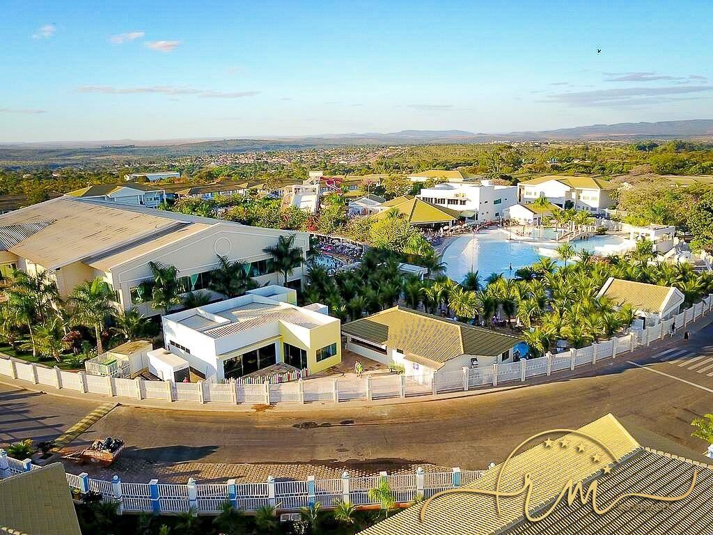 A resort with a swimming pool, multiple buildings, and a view of the surrounding landscape.