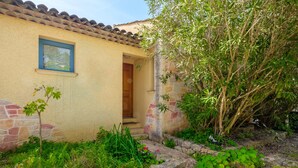 Una casa con fachada de piedra, puerta de madera y una ventana.