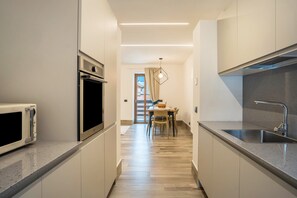 Een moderne keuken met een magnetron, oven en spoelbak.
