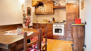 Eine Küche mit Holzschränken, einem Herd und einem Kühlschrank.