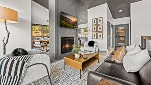 Una sala moderna con chimenea, un comedor con vistas y una zona de estar acogedora con un perro.