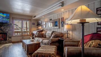 Tv, eldstad, ett bordtennisbord och printers