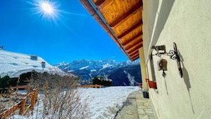 A snow-covered mountain landscape with a wooden building and a stone pathway.