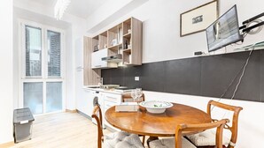 Una cocina moderna con armarios de madera, una mesa de comedor con sillas acolchadas y un ventanal grande.