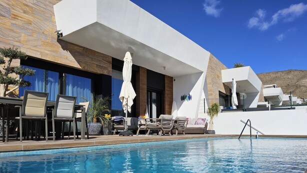 A modern pool area with lounge chairs and a covered seating area. - Benidorm eudaimonia by Interhome (Benidorm)