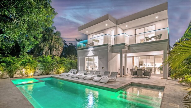 A modern two-story house with a swimming pool, outdoor seating, and lush greenery. - Tamiami Vice - Luxury Siesta Key Home with Heated Pool & Prime Location – Book Your Escape Today! (Sarasota)