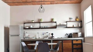 A modern kitchen with a central island, built-in appliances, and open shelving.