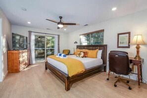 A bedroom with a bed, a desk, a chair, a ceiling fan, and a window. - Hot Tub & Game Room • Starlight Cabin Retreat (Oakhurst)