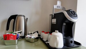 A coffee maker, a kettle, and a tray with cups and condiments on a table. - Arsenale Turin Room 3 (Torino)