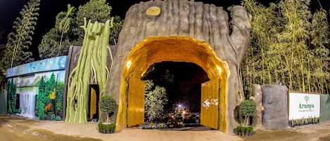 A large, illuminated archway entrance with a sign for Aranya The Meridian Resort.