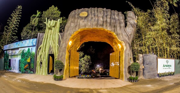 A large, illuminated archway entrance with a sign for Aranya The Meridian Resort.