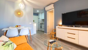 A modern living room with a sofa, glass coffee table, and a TV on a cabinet. - Voramar by Interhome (Calpe/Calp)
