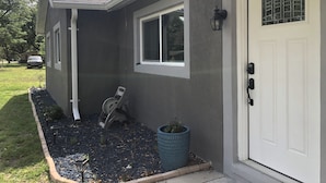 A residential house with a grey exterior, a white door, and a window. - Cozy ,Tranquil 3-bedroom in Spring Hill with WiFi, AC ; home away from home.  (Spring Hill)